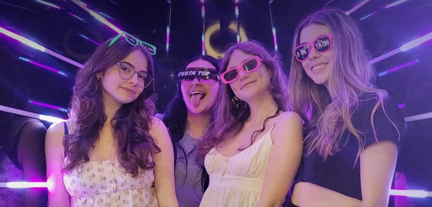 Convidadas se divertindo dentro do Túnel Infinity iluminado em roxo