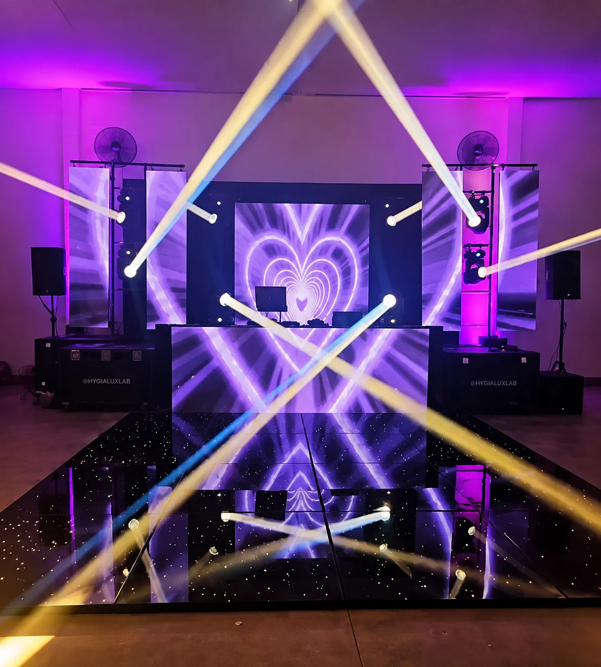 Painel de LED montado em palco com projeção de coração e iluminação roxa